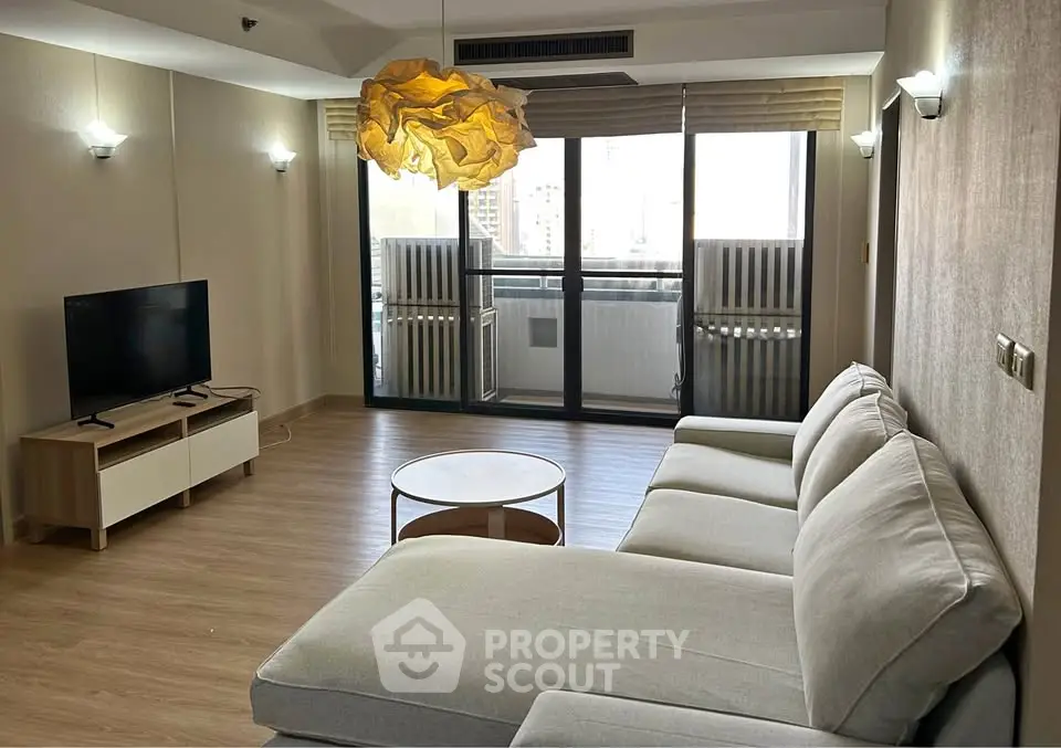 Spacious modern living room with large sofa and balcony view