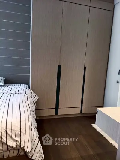Modern bedroom with sleek wardrobe and stylish striped bedding