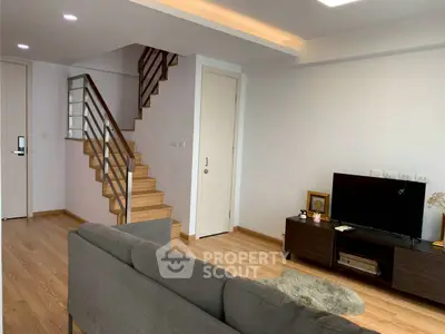 Modern living room with wooden staircase and sleek furniture