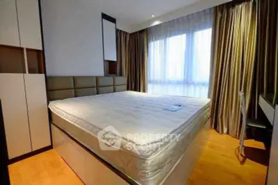 Spacious bedroom with large bed and natural light from window, featuring modern design and ample storage.