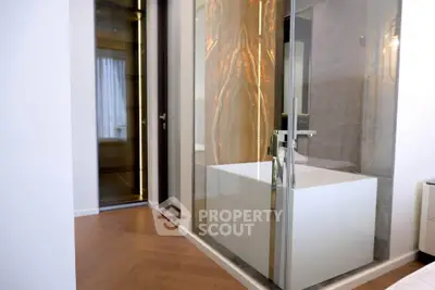 Luxurious modern bathroom with glass shower and elegant wood flooring