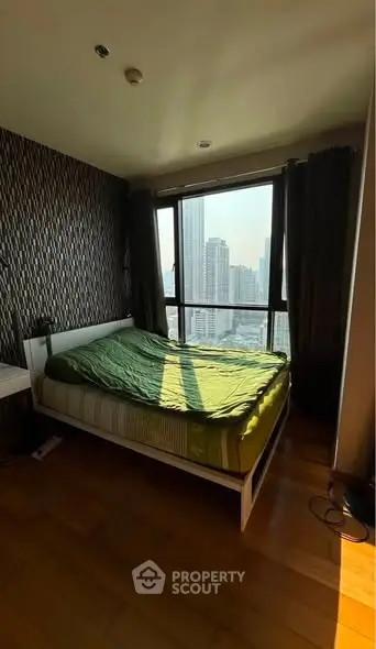 Cozy bedroom with city view, featuring a modern bed and stylish decor, perfect for urban living.