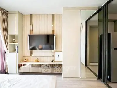 Modern bedroom with sleek TV setup and mirrored wardrobe