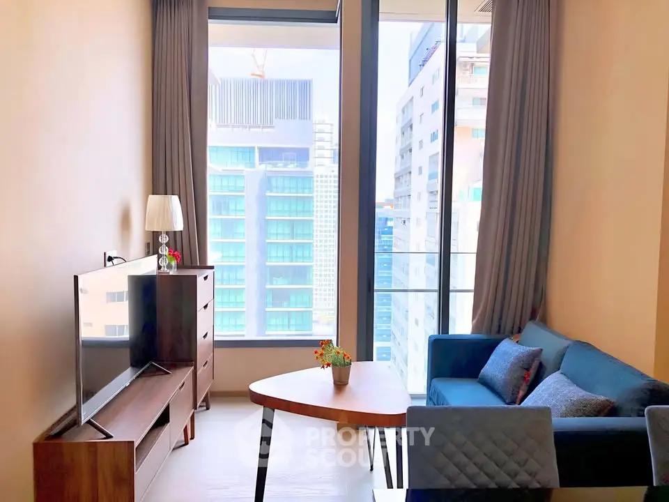 Modern living room with large windows and city view, featuring stylish furniture and natural light.