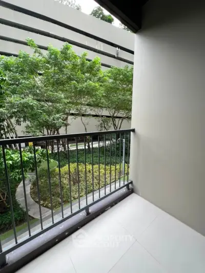 Charming balcony with lush garden view in modern apartment complex