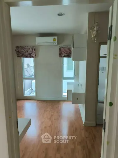 Bright and airy room with wooden flooring and air conditioning, perfect for modern living.