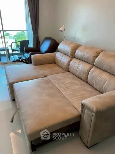 Spacious living room with modern beige sofa and natural light