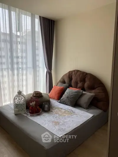 Cozy bedroom with large window and stylish decor in modern apartment