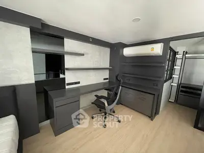 Modern study room with sleek desk, ergonomic chair, and built-in shelves in a stylish apartment.