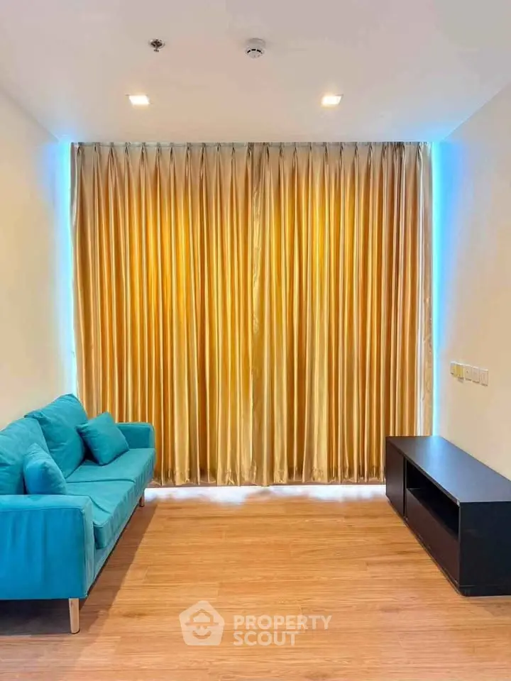 Modern living room with teal sofa and golden curtains, perfect for cozy relaxation.