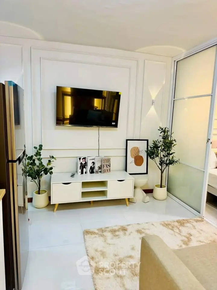 Modern living room with stylish decor, wall-mounted TV, and cozy seating area in a contemporary apartment.