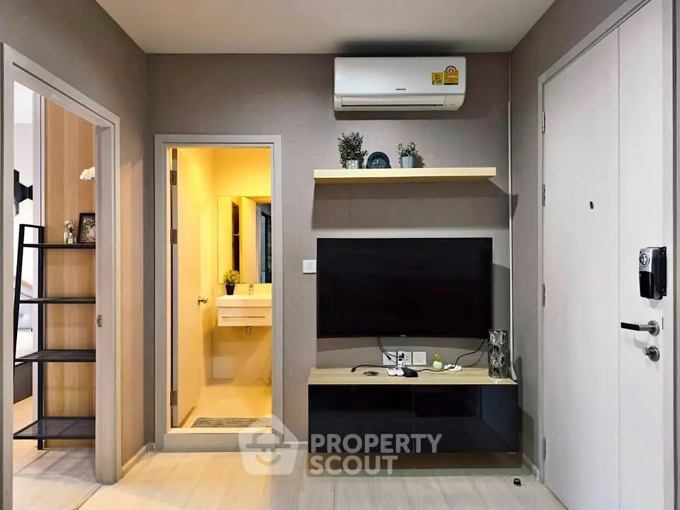 Modern living room with sleek TV setup and air conditioning in a stylish apartment.