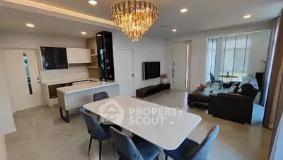 Luxurious open-plan living and dining area with modern kitchen and elegant chandelier.