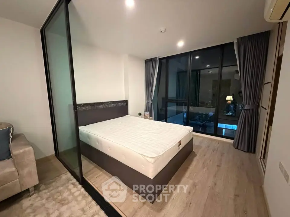Modern bedroom with glass partition and cozy lighting in a stylish apartment