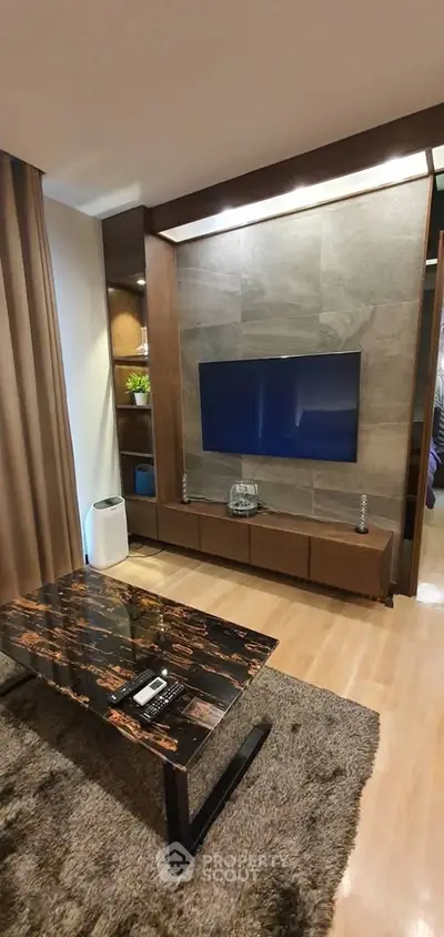 Modern living room with stylish decor and mounted TV, featuring a sleek marble coffee table and cozy ambiance.