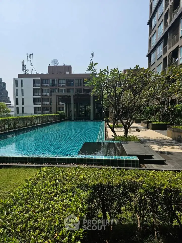Luxurious apartment complex with stunning outdoor pool and lush greenery, perfect for relaxation and leisure.