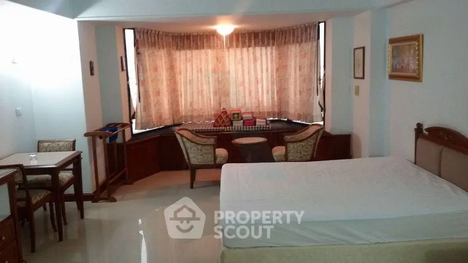 Spacious studio apartment with large windows and elegant furnishings