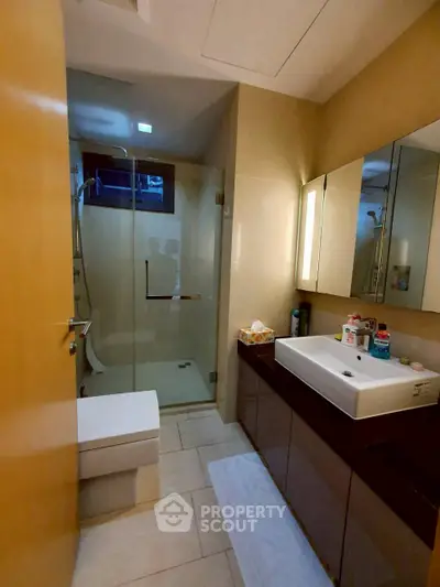 Modern bathroom with glass shower and sleek vanity in luxury home.