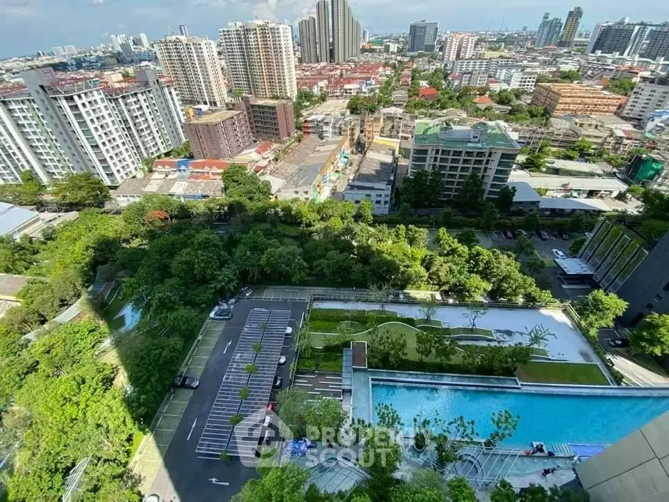 Stunning aerial view of urban landscape with lush greenery and modern buildings, featuring a sleek swimming pool.
