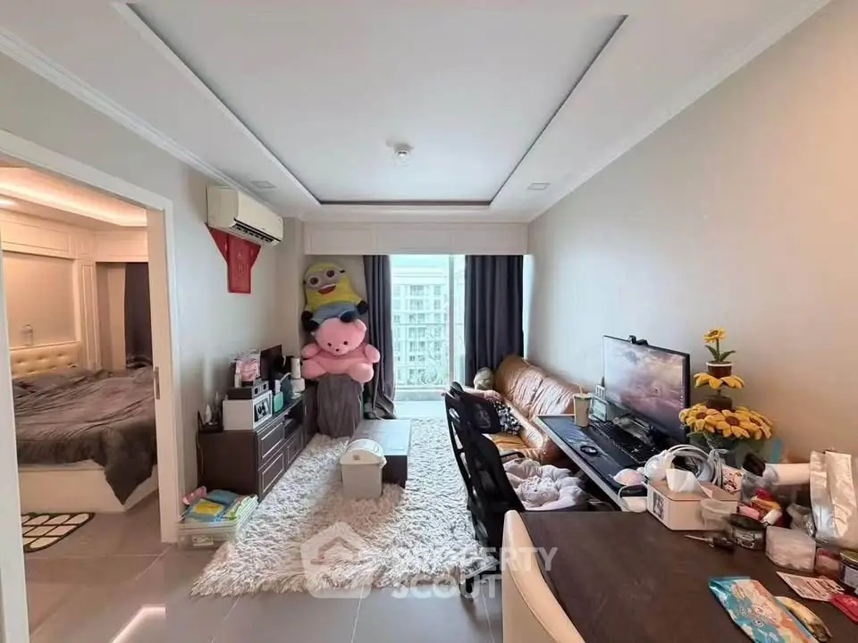 Cozy living room with modern decor and natural light, adjacent to a stylish bedroom.