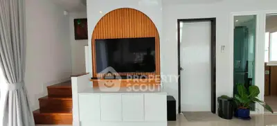 Modern living room with sleek TV setup and stylish wooden accents