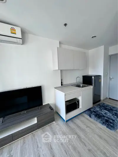 Modern compact kitchen with sleek cabinetry and integrated appliances in a stylish apartment.