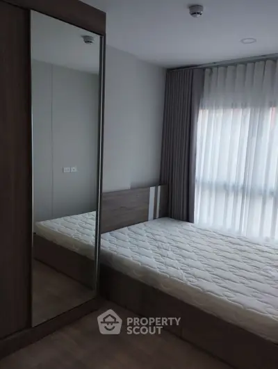 Modern bedroom with large mirrored wardrobe and natural light