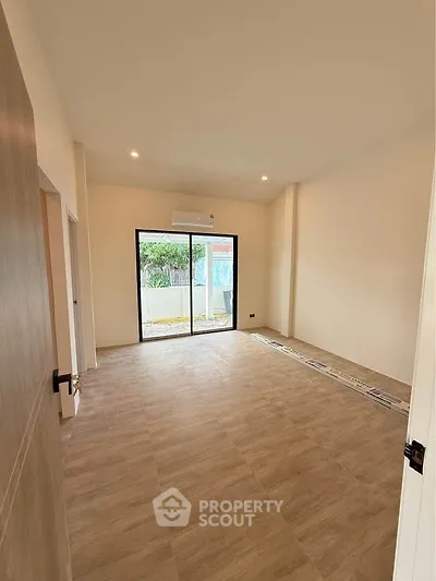 Spacious unfurnished room with large window and air conditioning unit