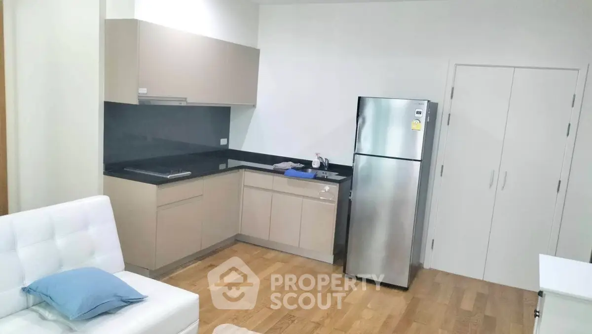 Modern kitchen with sleek cabinetry and stainless steel fridge in open layout