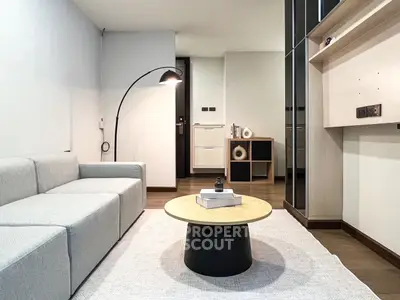 Modern living room with sleek furniture and stylish decor, featuring a cozy sofa and contemporary lighting.