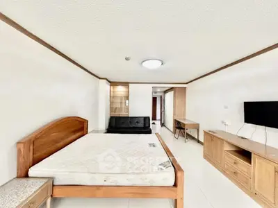 Spacious bedroom with modern furnishings and ample natural light, perfect for comfortable living.