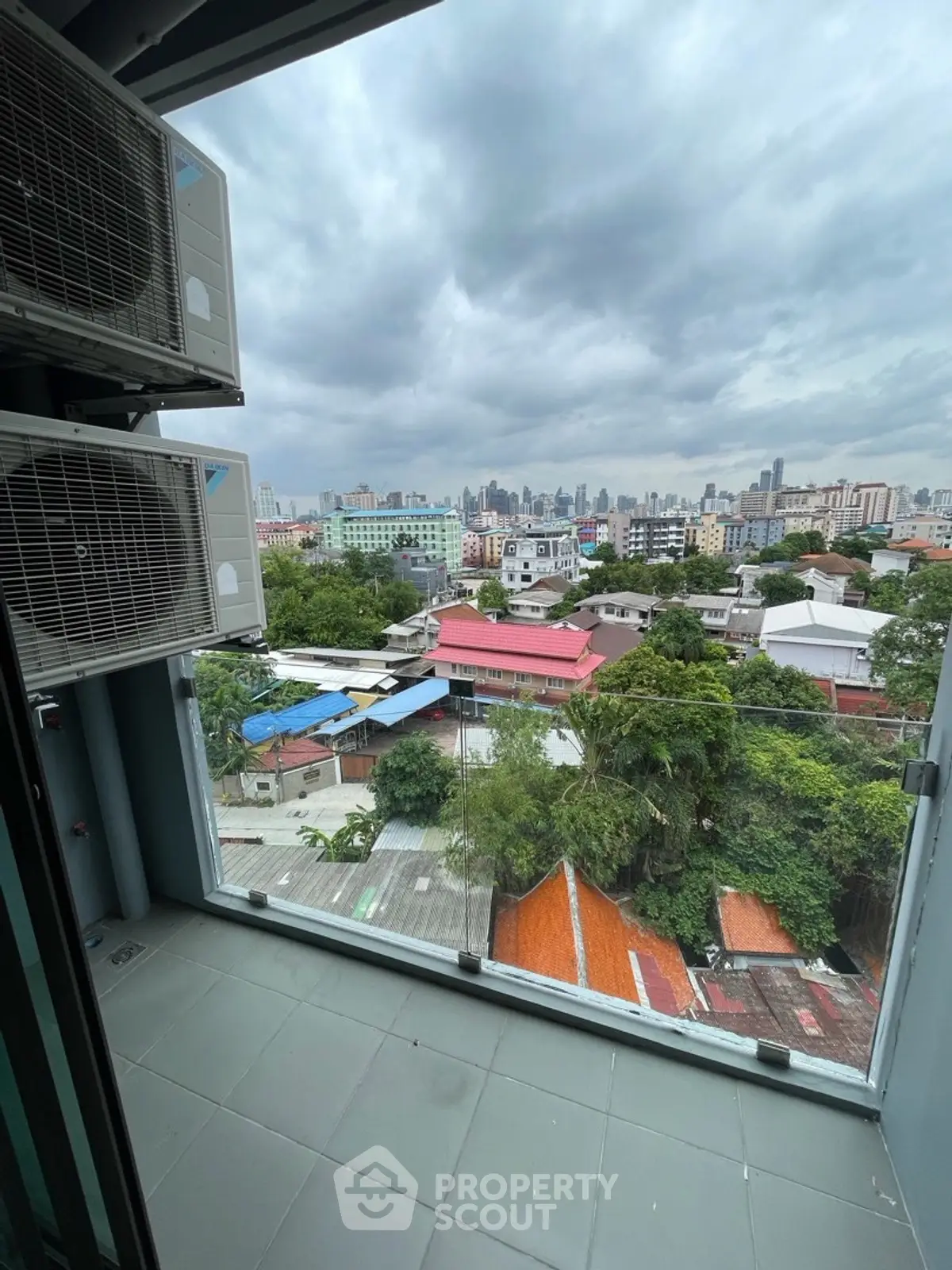 Stunning cityscape view from a modern balcony with glass railing, perfect for urban living.