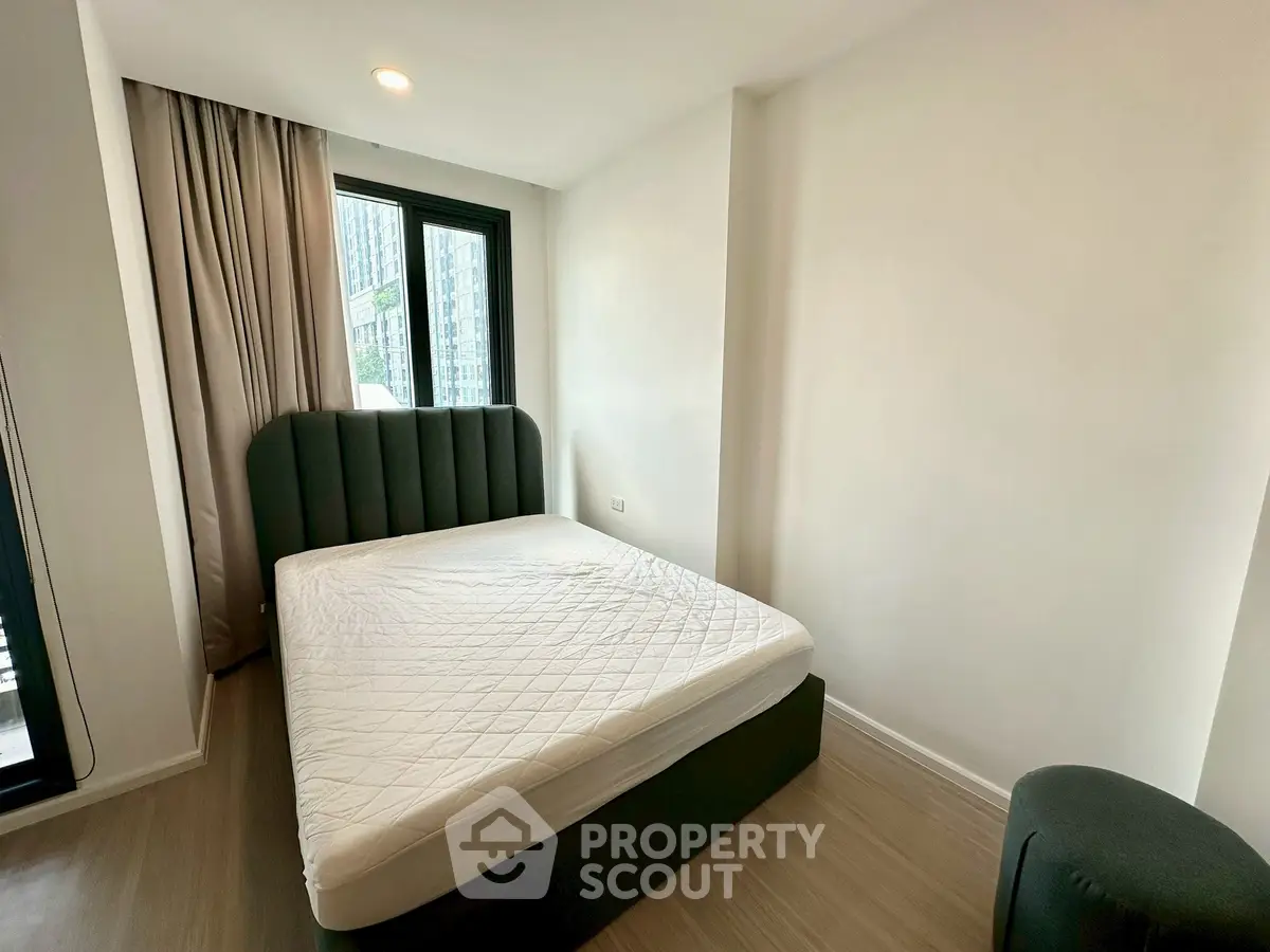 Modern bedroom with stylish bed and large window in a bright apartment