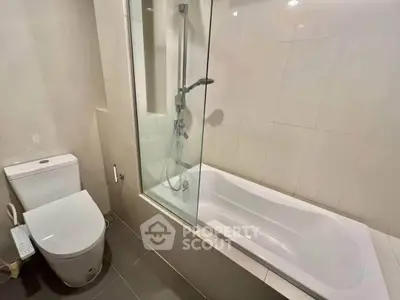 Modern bathroom with sleek bathtub and shower combo, ideal for contemporary living.