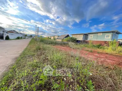Scenic view of residential land plot with clear skies and surrounding homes, ideal for development.