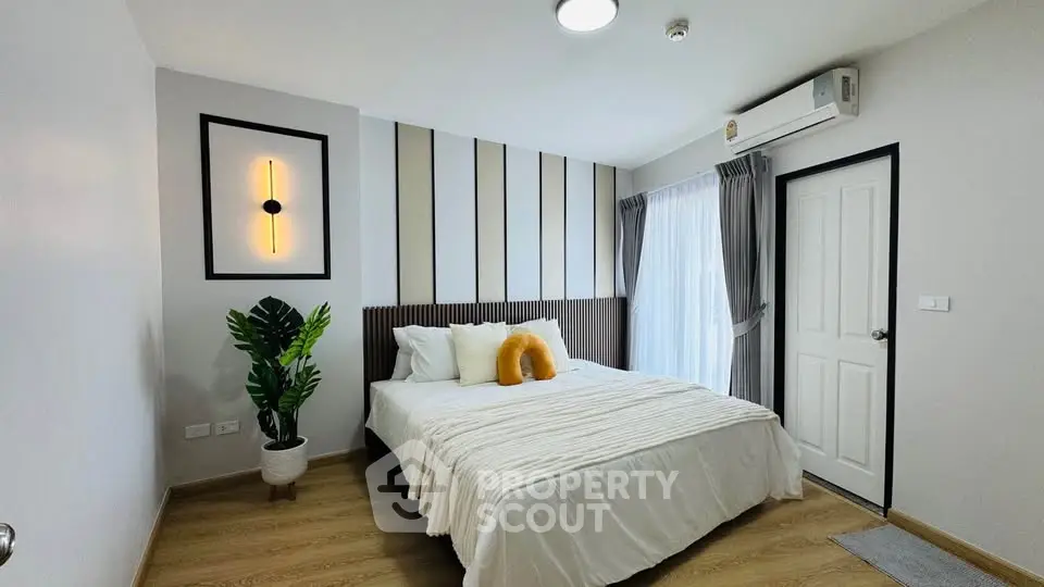 Modern bedroom with stylish decor and natural light, featuring a cozy bed and elegant wall design.
