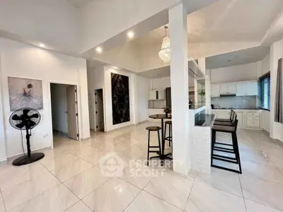 Spacious open-plan kitchen and living area with modern design and elegant lighting.