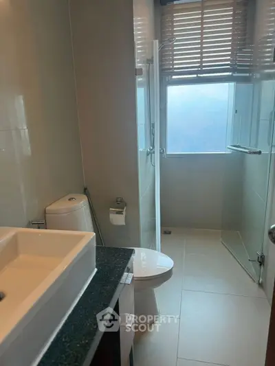Modern bathroom with sleek fixtures and large window for natural light.