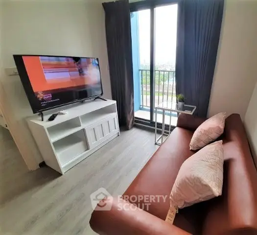 Cozy living room with modern TV setup and balcony view