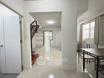 Spacious open-plan living area with modern staircase and dining setup