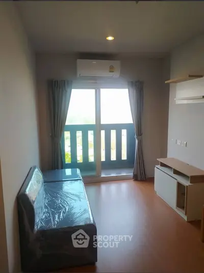 Modern living room with balcony and air conditioning in a cozy apartment.