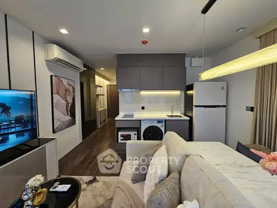 Modern living room with open kitchen, featuring sleek appliances and stylish decor in a contemporary apartment.