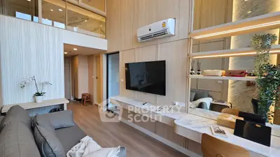 Modern living room with stylish decor and open layout, featuring a wall-mounted TV and air conditioning.