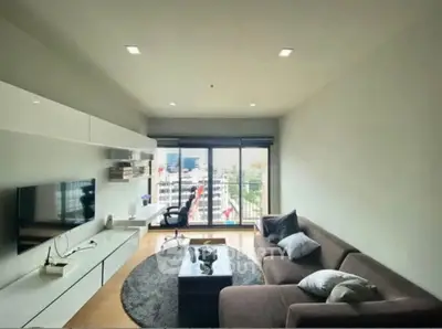 Modern living room with city view, sleek furniture, and natural light.