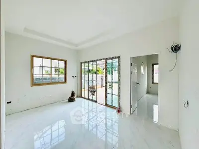 Spacious living room with large windows and sliding glass doors opening to a patio.
