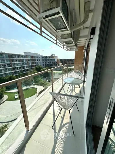 Modern balcony with stylish seating and scenic view of residential complex