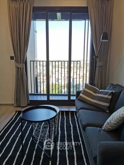 Stylish living room with balcony view, modern decor, and natural light.