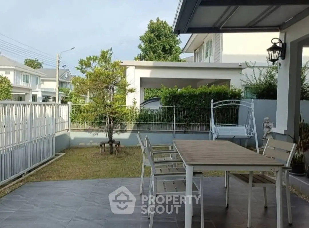 Charming outdoor patio with modern furniture and lush garden view in a serene residential area.