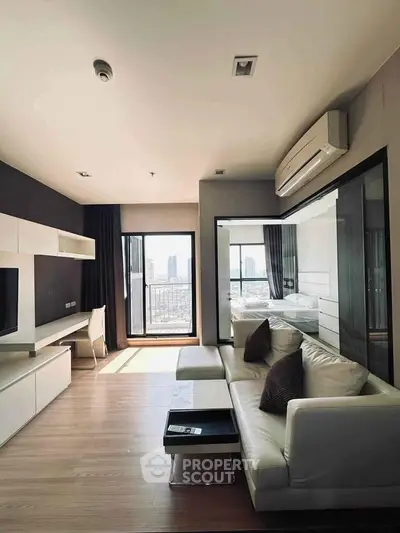 Modern living room with sleek furniture and city view, featuring a cozy white sofa and wall-mounted TV.