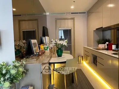 Modern kitchen with sleek cabinetry and ambient lighting, featuring a stylish dining area and decorative plants.